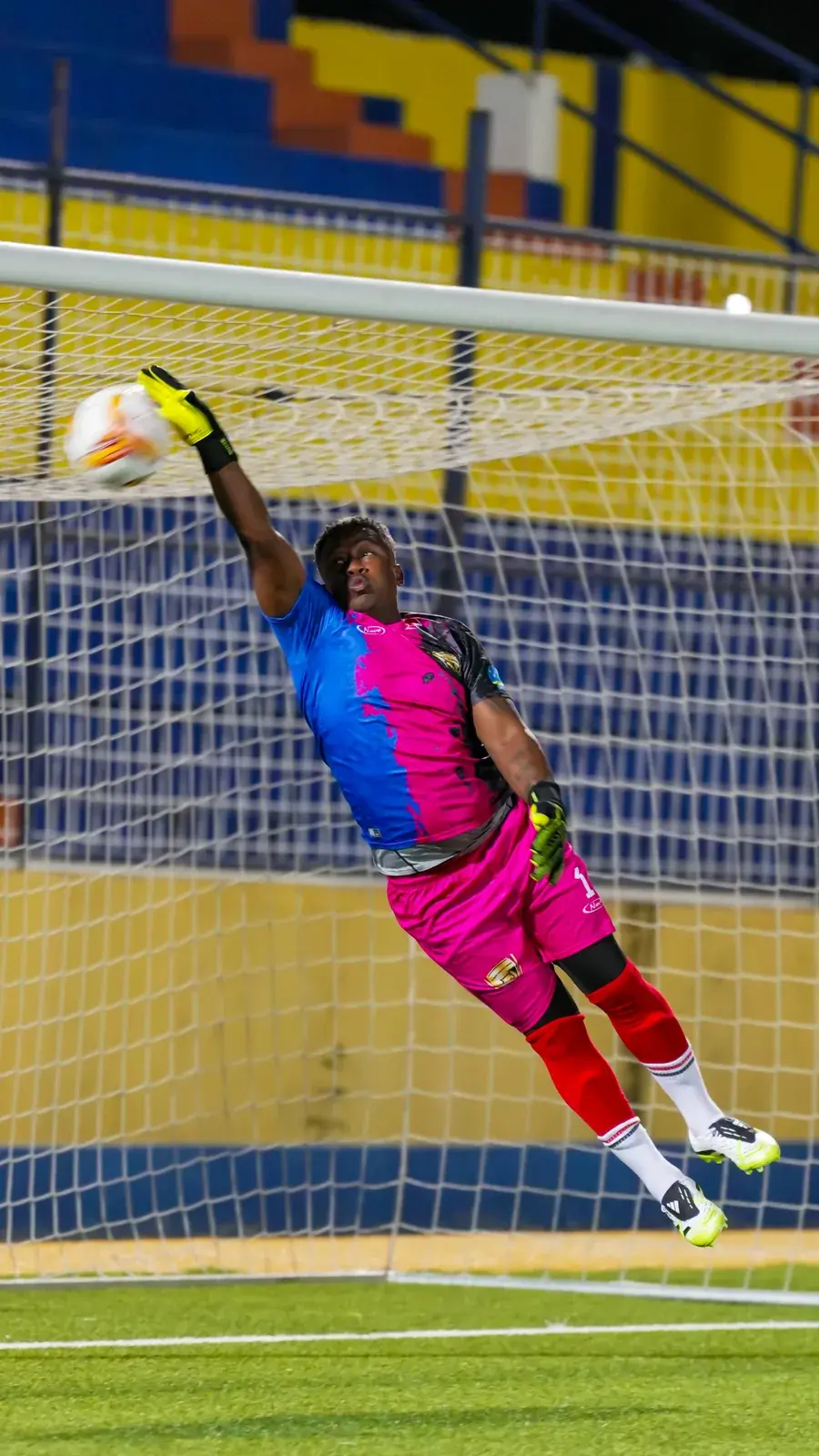 The West Wolves United goalkeeper reaching for the ball in front of goal.